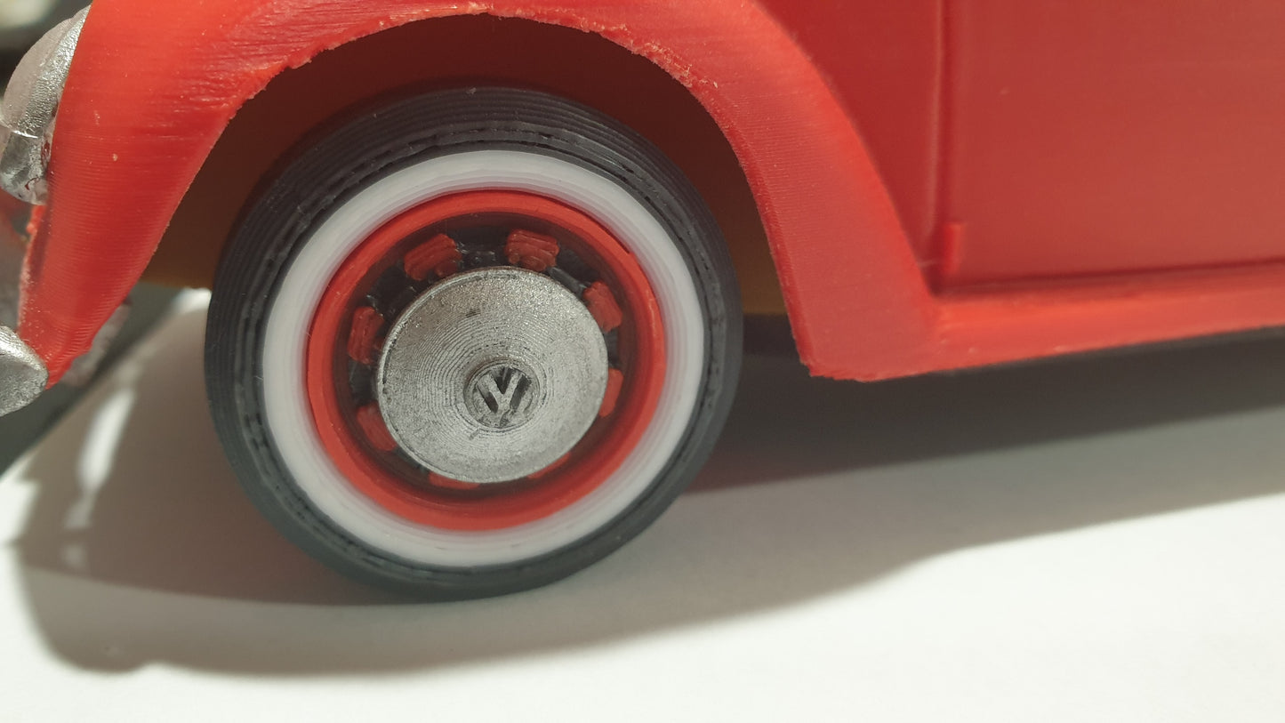 Close-up of a 1963 VW Beetle's red and white wheel with a VW emblem in the center, evoking automotive nostalgia. The body of the car is also visible in a bright red color, perfect for those seeking an STL File : 1963 VW Beetle Vehicle by Gordon Nezich to capture this classic beauty.