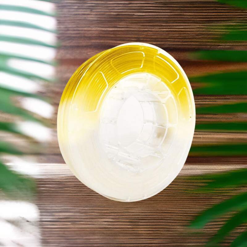 A yellow and white plastic spool of Hello3D PLA Light Change Colours 1.75mm 3D Printing Filament on a wooden table.