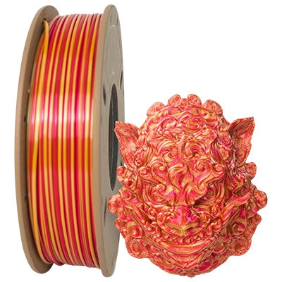 A spool of Toyar PLA Silk Rainbow Colours Alternating 1.75mm filament from ShenZhen Toyar Technology sits beside an intricately 3D printed lion head, both in a stunning red-orange gradient, ideal for vibrant 3D projects.