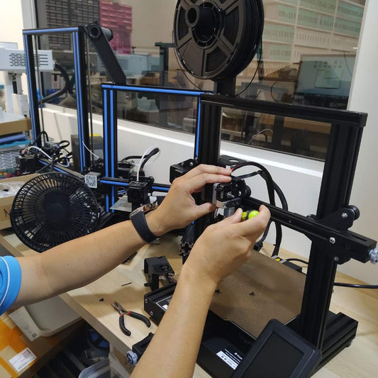 A man is Repairing a 3d printer.