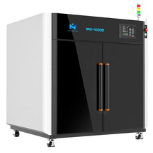 The 3D Printer MINGDA MD-1000D for Commercial 1m X 1m X 1m is a large industrial machine with a black front panel. This impressive large format printer features the brand name "MINGDA" prominently and includes two vertical handles and a control panel with a small screen displaying various indicators.