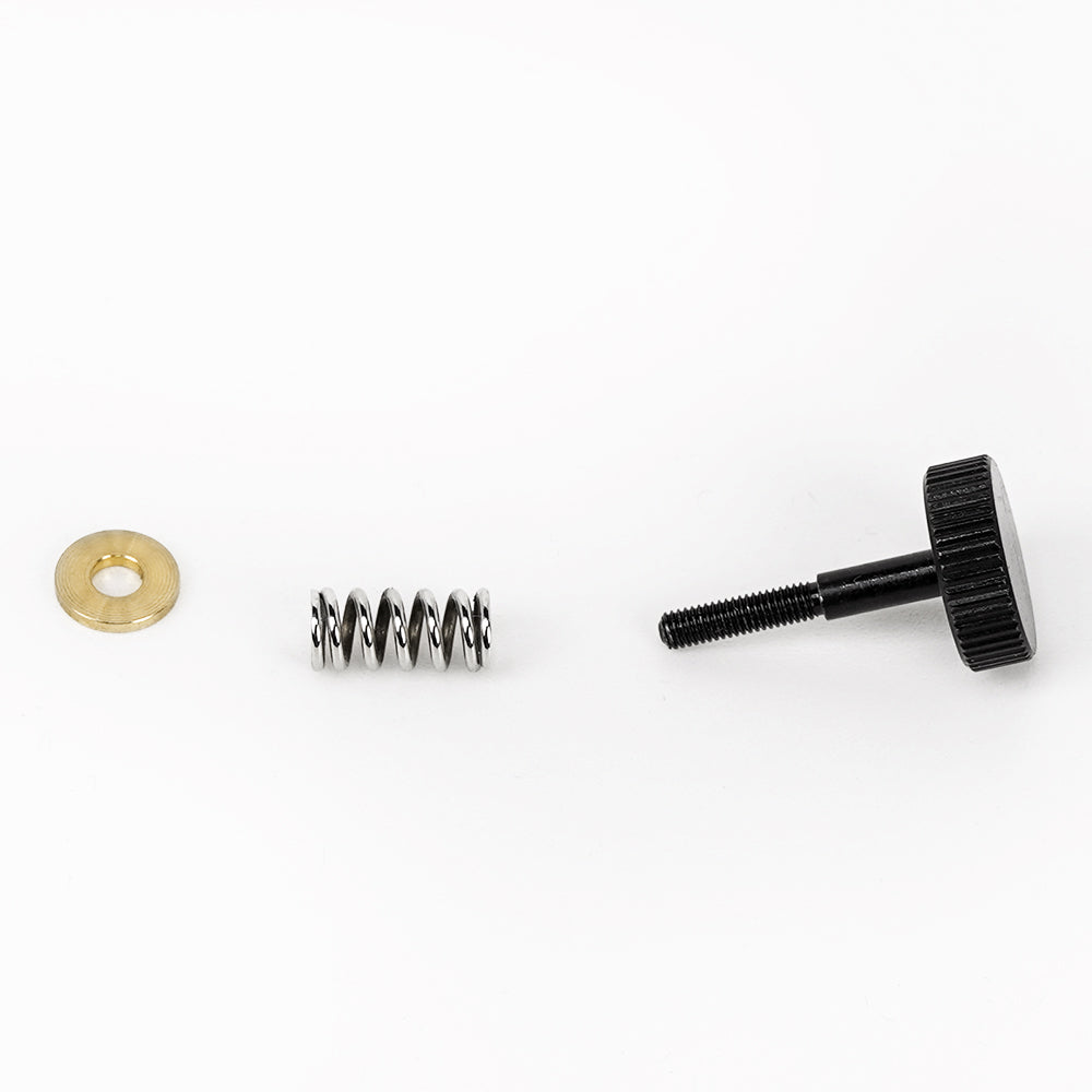 A set of MINGDA Magician Filament Feeding Extruder adjustment screws and a spring on a white surface, part of Mingda Magician Series.
