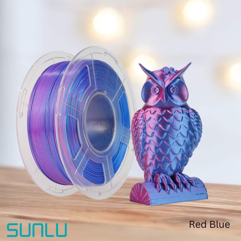 An eco-friendly spool of Filament - SUNLU PLA+ Silk Dual Colour 1.75mm 3D Printing Filament in red and blue next to an owl figurine.