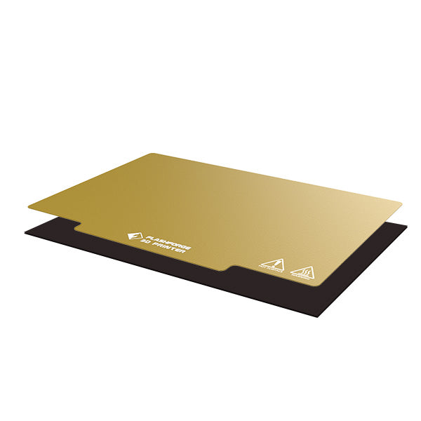 The PEI Sheet and Magnet Tape Assembly for the Creator Pro Series by Flashforge includes two stacked rectangular layers, one gold and one black, with the top layer displaying branding and caution symbols.