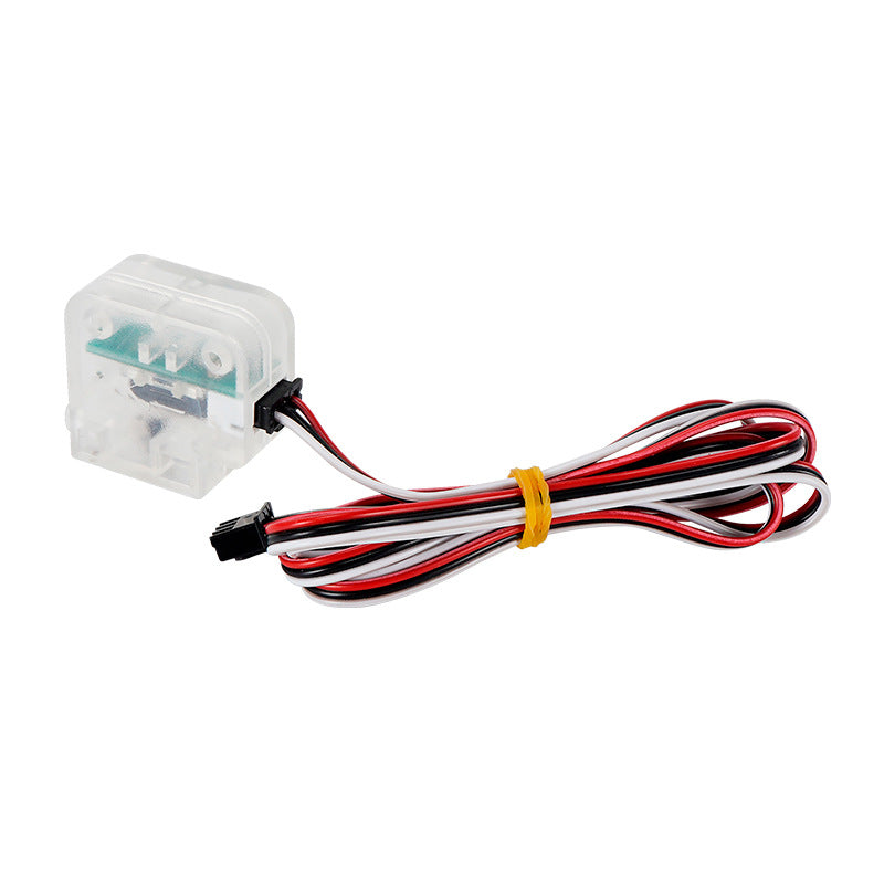 The 3D Printing Filament Detector by Cirrus Link features a see-through plastic sensor with a black, red, and white cable bundled with an orange rubber band, ideal for detecting broken filament in 3D printing setups.