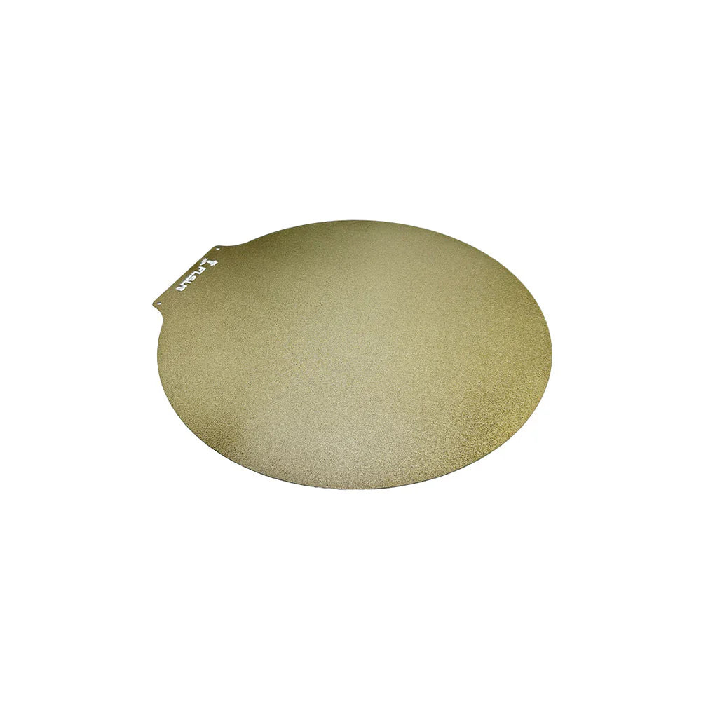 A circular metal plate with a small tab on one side. The surface has a slight texture, a gold-like color, and is perfect for use as an FLSUN Flsun V400 removable PEI Plate 300mm in your 3D printing projects.