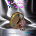 A spool of Toyar PLA Silk Tri Colour 1.75mm 3D Printing Filament on a silver surface.