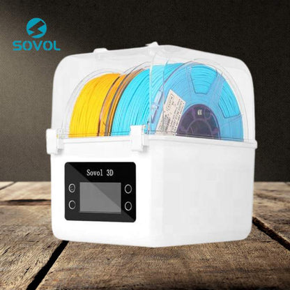A SOVOL Sovol Filament Dual Bay Dryer SH01 with two spools of 3D printer filament, one yellow and one blue, is displayed on a wooden surface.