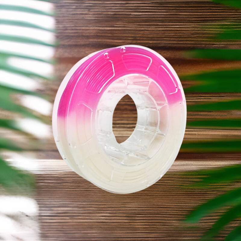 A pink Hello3D PLA Light Change Colours 1.75mm 3D Printing Filament spool hanging on a wooden wall.