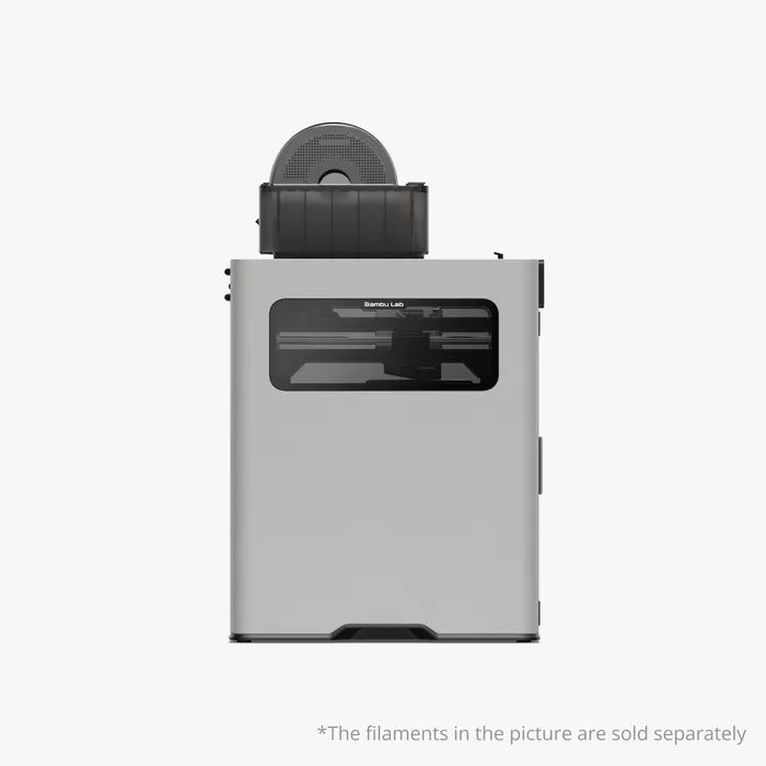 The Bambu Lab H2D 3D Printer by Bambu Lab is shown with a filament spool on top and a transparent front panel. Featuring dual-nozzle technology for versatile multi-material printing. Filaments sold separately.