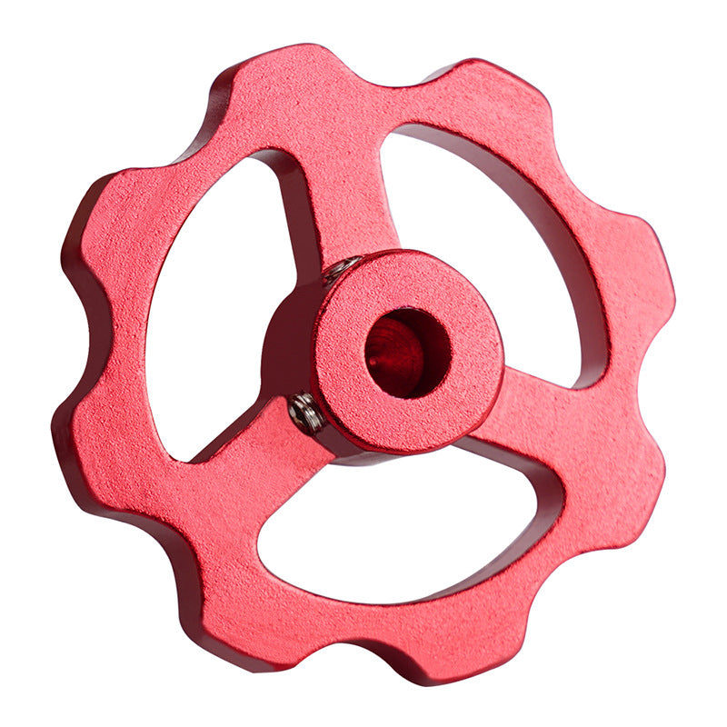 The 3D Printing Perth - Cirrus Link Motor Manual Nut for E-axis Extruder is a red, gear-shaped metal component with a jagged edge and three spokes, ideal for smooth functionality in 3D printer applications such as stepper motor nuts.