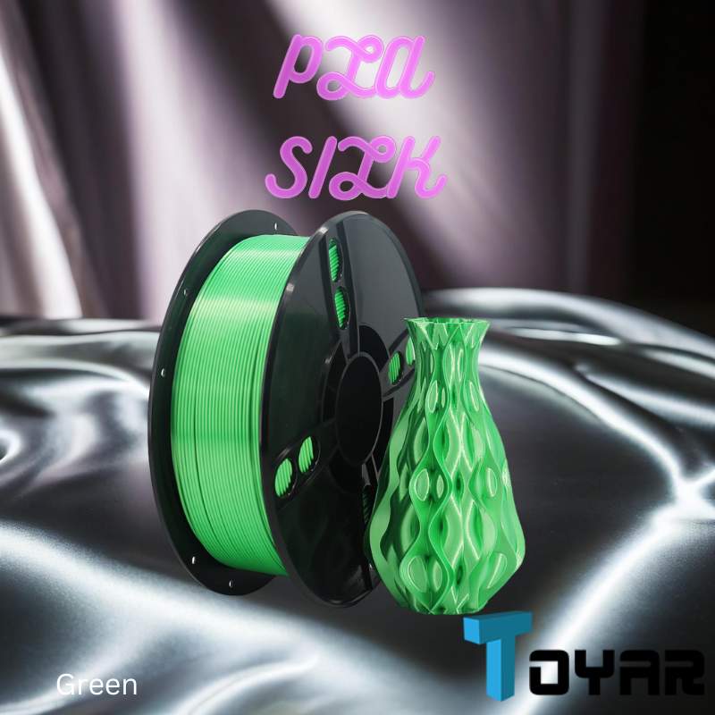 A green spool of Toyar PLA Silk Standard Colour 1.75mm 3D Printing filament for 3D printing on a silver surface.