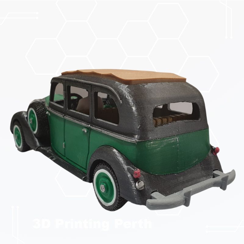 A 3D printed model of a 1930s Mercedes with a green body, black fenders, and a brown roof, displayed against a white background is the STL File: 1930 Mercedes Vehicle by Gordon Nezich.