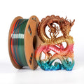 A spool of Toyar PLA Silk Rainbow 1.75mm 3D Printing Filament stands beside a vibrant, rainbow-colored PLA dragon sculpture on a white background.