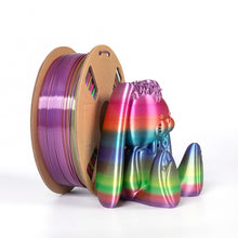 A spool of Toyar PLA Silk Rainbow 1.75mm 3D Printing Filament is placed beside a vibrant gradient bear figurine, both showcasing the colorful pattern on a white background.