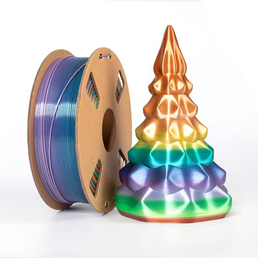 A spool of Toyar PLA Silk Rainbow 1.75mm filament sits beside a vibrant geometric tree sculpture, both showcasing the stunning colors achievable with Toyar’s rainbow 3D printing filament.