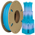 A spool of Toyar PLA Matte Rainbow 1.75mm Filament sits next to a blue and white 3D-printed multi-story building, highlighting its matte finish perfect for detailed prints.