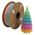 A spool of Toyar PLA Matte Rainbow 1.75mm Filament is beside a pastel, cone-shaped 3D print with layered colors like a stylized tree, showcasing Toyar's smooth matte finish.