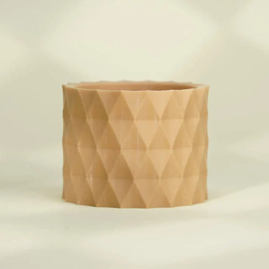 A beige, round planter with a faceted geometric pattern—crafted from Flashforge PLA 1.75mm Basic Colour 3D Printing Filament—sits on a light, neutral background.
