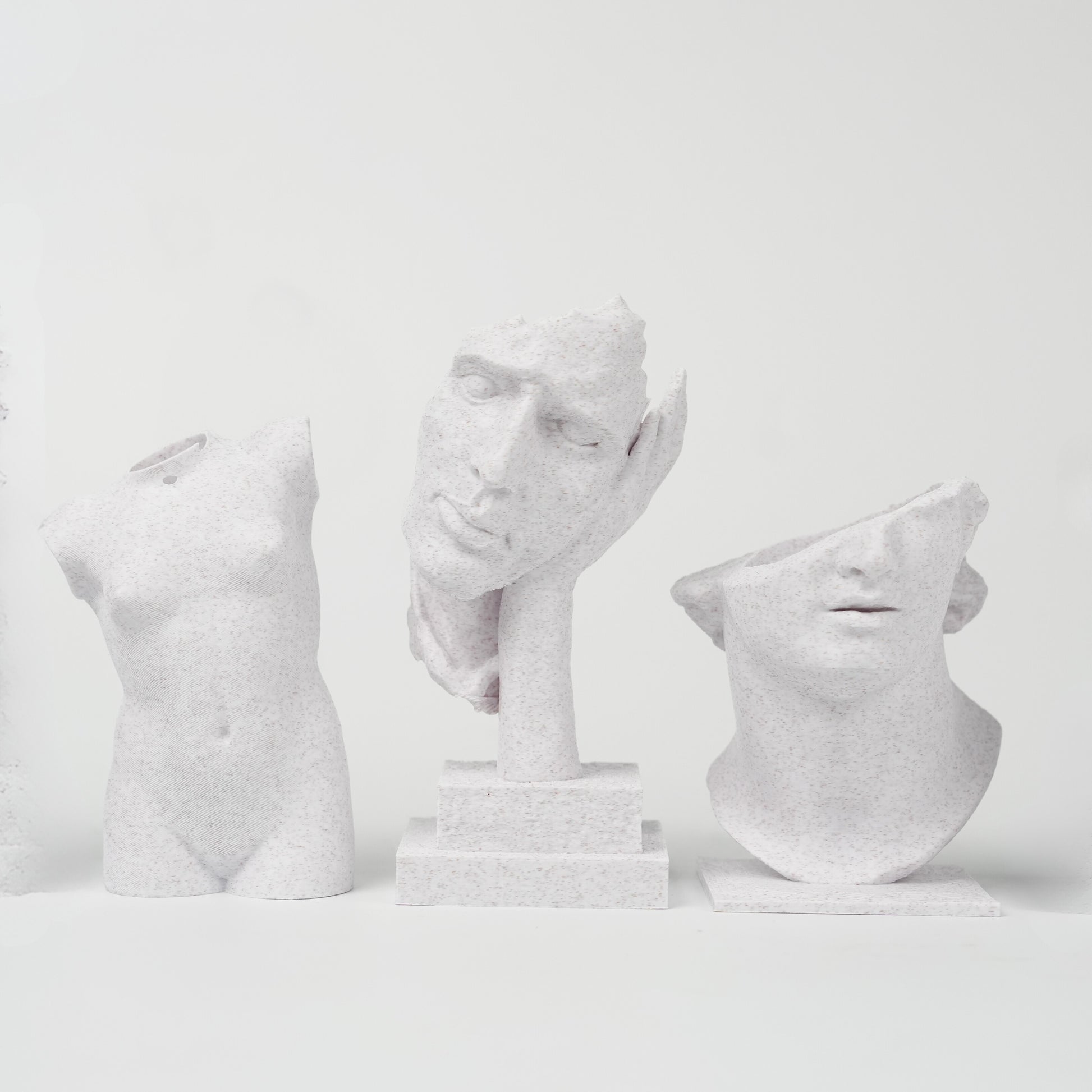 Three sculptures 3D printed with Flashforge HS PLA 1.75mm Filament in Marble Colour stand against a plain white background, each featuring a smooth surface finish that highlights the quality of Flashforge’s material.