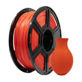 A spool of Flashforge PLA Matte Colour 1.75mm 3D Printing Filament in vibrant orange sits beside a small, precisely 3D printed vase in the same shade.