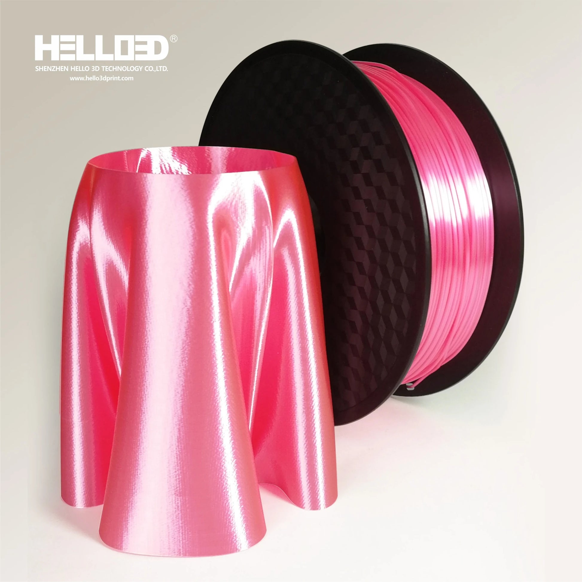 A spool of Hello3D PLA SILK Colour 1.75mm Filament stands by a glossy pink 3D-printed skirt, showing the luxurious finish possible with Hello3D’s 3D printing filament.