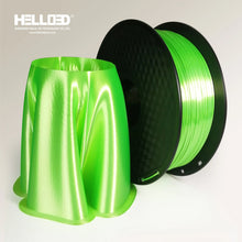 A spool of Hello3D PLA SILK Colour 1.75mm filament sits beside a 3D printed object made from the same Hello3D 3D printing filament, both displayed on a white background for luxury prints.