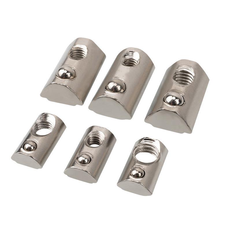 Six Aluminium Profile Elastic Ball Nut Type 20s by 3D Printing Perth - Cirrus Link, akin to those used in aluminium profile applications, feature a silver finish with varying sizes and hole diameters. These semi-cylindrical nuts are neatly arranged in two rows on a white background, embodying elements of precision seen in linear motion systems.