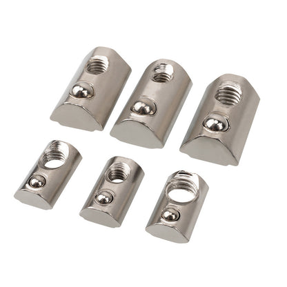 Six Aluminium Profile Elastic Ball Nut Type 20s by 3D Printing Perth - Cirrus Link, akin to those used in aluminium profile applications, feature a silver finish with varying sizes and hole diameters. These semi-cylindrical nuts are neatly arranged in two rows on a white background, embodying elements of precision seen in linear motion systems.