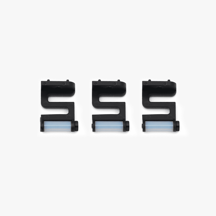 Three identical black plastic Bambu Lab Nozzle Cleaning Module - Nozzle Wipers with light blue rollers, arranged in a row on a white background, designed by Bambu Lab to help prevent filament overflow during 3D printing.