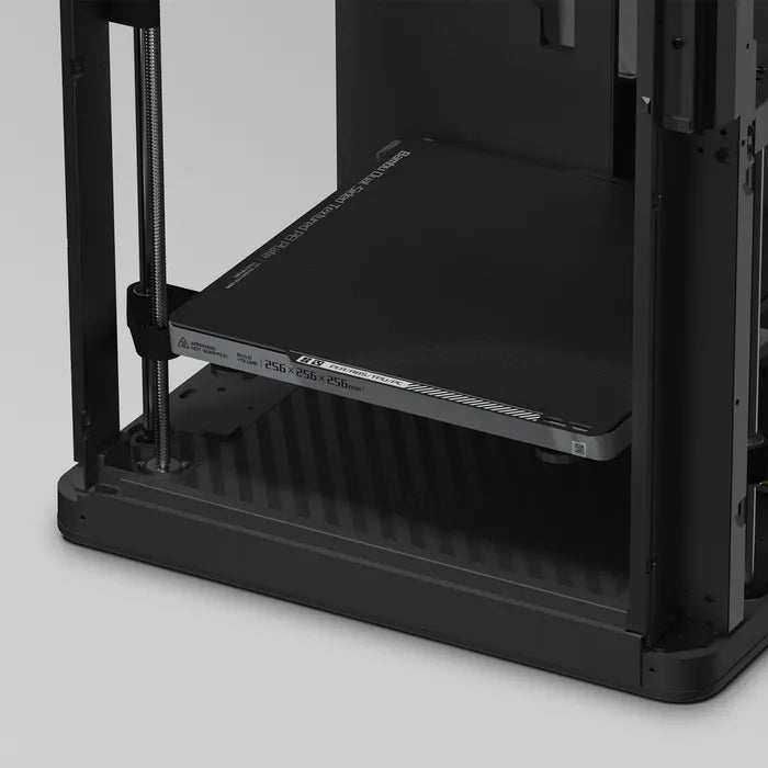 Close-up of the Bambu Lab P1P 3D Printer’s lower section, showcasing the print bed and vertical support rods designed by Bambu Lab for high-speed 3D printing.
