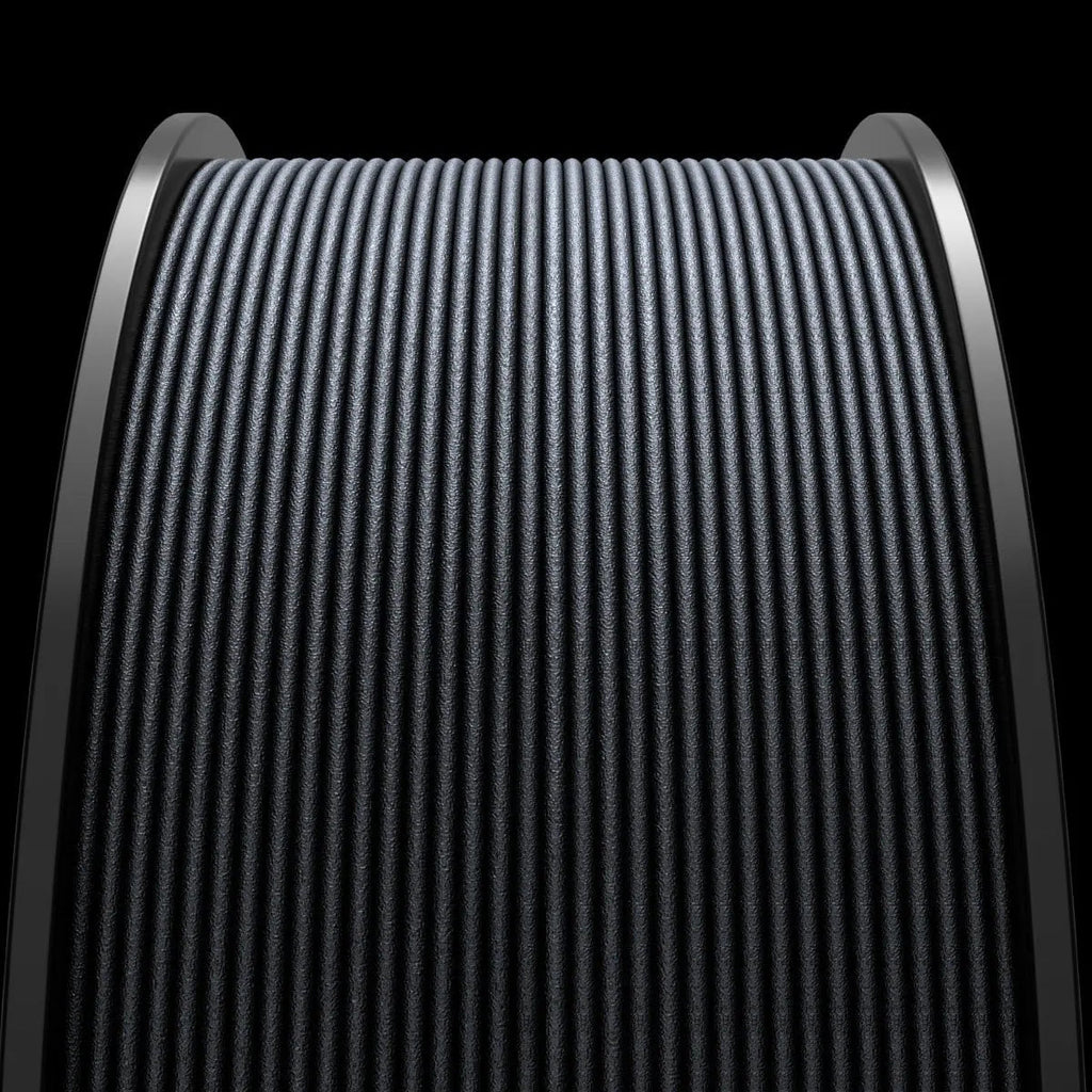 Close-up of a Filament - MakerHero CF Blend™ PLA Carbon Fibre Reinforced black textured fabric tightly wound on a cylindrical roller, displayed against a dark background.
