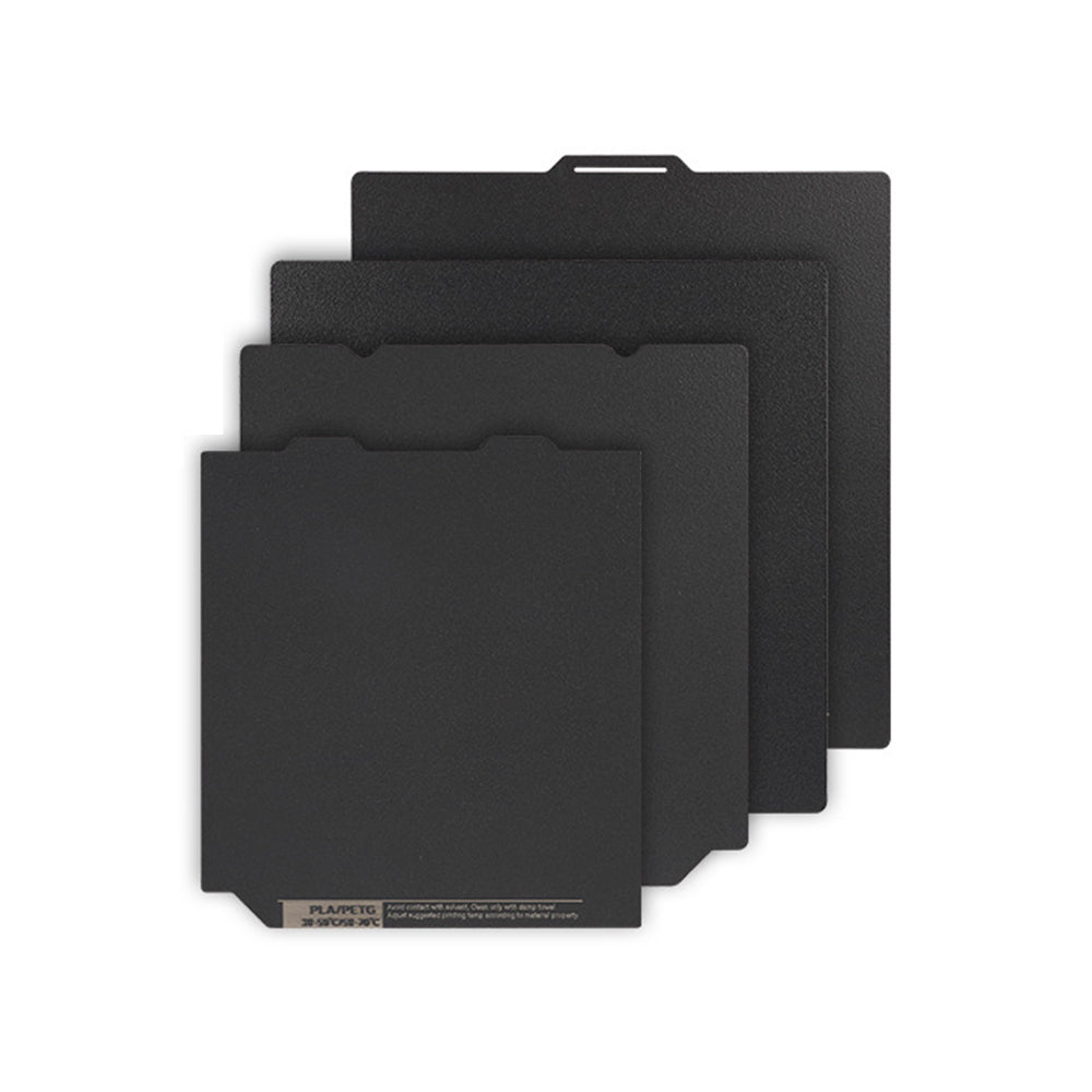 Four black swatches of the Polyurea Hot Bed Platform, each differing in size, are stacked and fanned out against a white background, showcasing the precision associated with 3D Printing Perth - Cirrus Link's products for materials like PLA, PETG, and ABS.