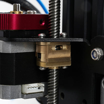 Close-up of a 3D printer’s Z-axis with brass lead screw nut, threaded rod, stepper motor, and metal frame—perfect for installing the 3D Printing Perth - Cirrus Link Oldham Coupler T8 Z Axis Screw Upgrade for BLV Ender 3 Creality Machines.
