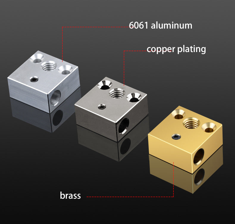 The CNC CR10/Ender 3 Heat Blocks from 3D Printing Perth - Cirrus Link, made from 6061 aluminum with copper plating and brass, showcase advanced CNC design with multiple threaded holes. They perform reliably at high temperatures on a reflective surface.