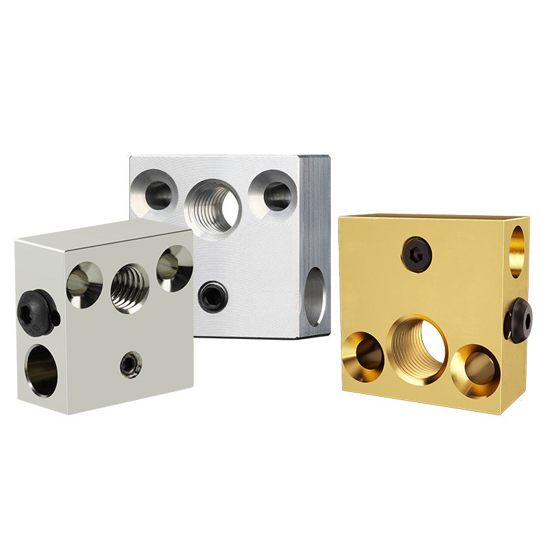 Three metal blocks with threaded holes in silver, gold, and matte gray finishes are showcased upright on a plain background, highlighting advanced CNC design for 3D Printing Perth - Cirrus Link's CR10/Ender 3 Heat Block in 400C and 550C options.