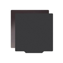 Two overlapping square plates, one featuring a carbon fiber texture and the other plain black, are arranged diagonally with the textured plate on top, evoking the sophisticated design of the PEI PET Bed Platform Steel Sheet Magnetic Base by 3D Printing Perth - Cirrus Link.
