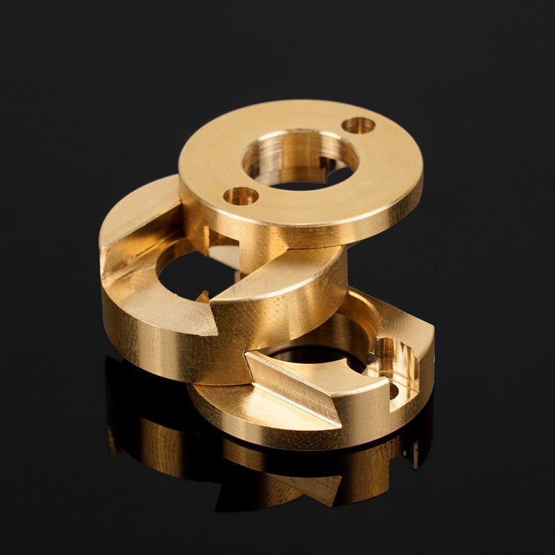 Two precision-machined brass components—the Oldham Coupler and T8 Z-Axis Screw Upgrade for Ender 3 BLV Correction by 3D Printing Perth - Cirrus Link—featuring circular and angular cutouts, are stacked on a reflective black surface.